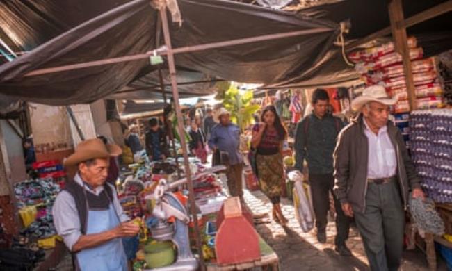 People walking through the main market of San Miguel Ixtahuacán